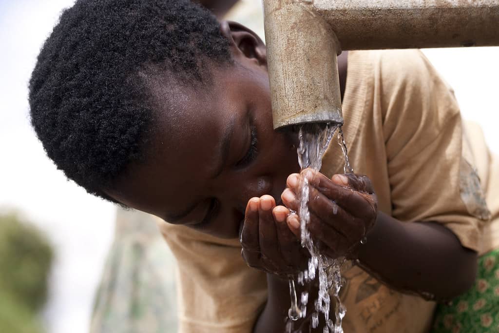 child drinking water from a tap