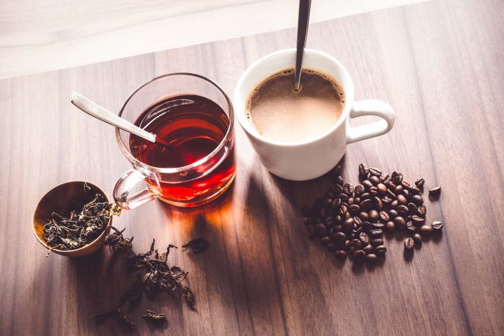 Coffee and tea with coffee bean and tea leaves on wooden floor