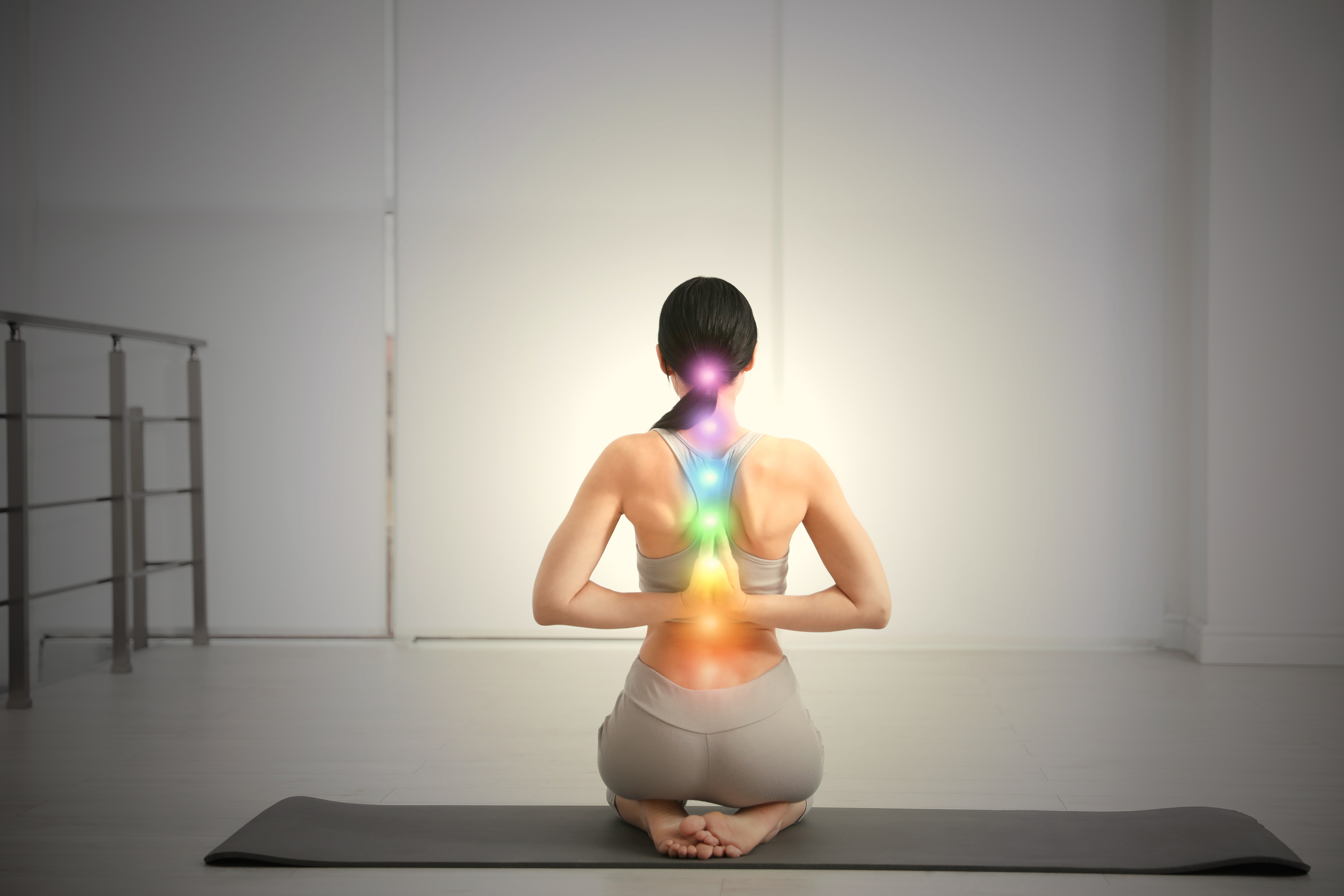 Young woman with chakra points practicing yoga