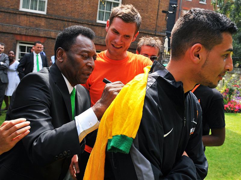 Pele signing a shirt for a brazilian fan