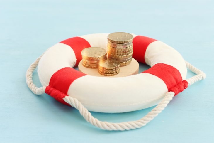 Concept image of lifebuoy and stack of coins, metaphor for financial aid