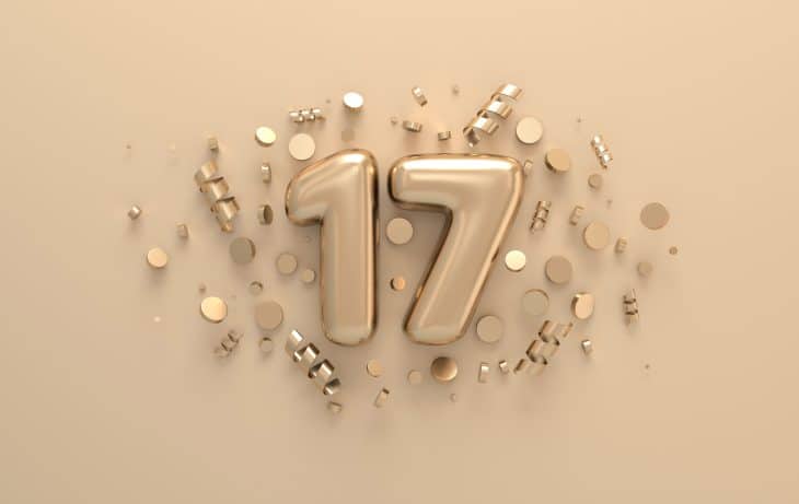 Golden 3d number 17 with festive confetti and spiral ribbons