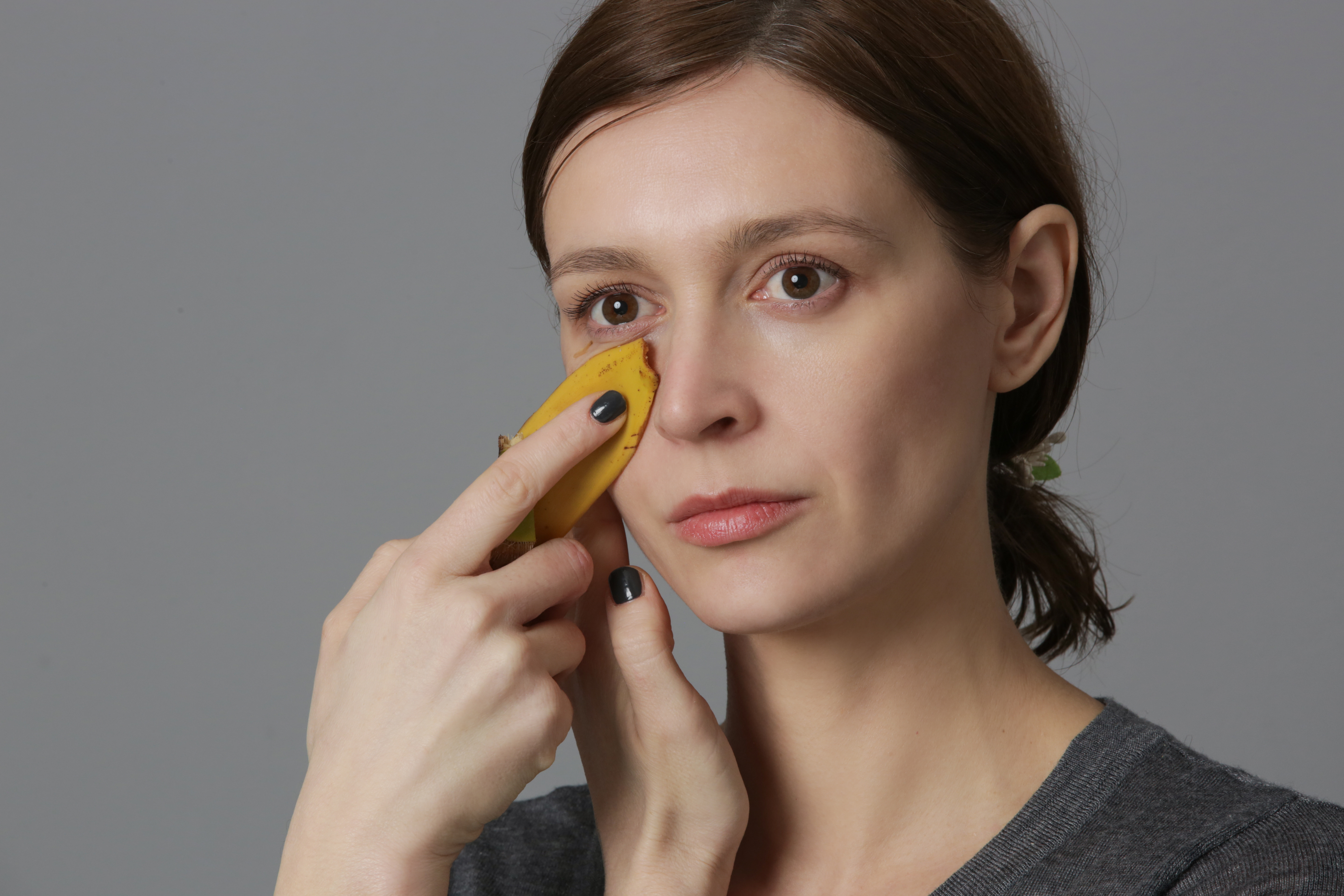 Woman rubbing banana peel on her face