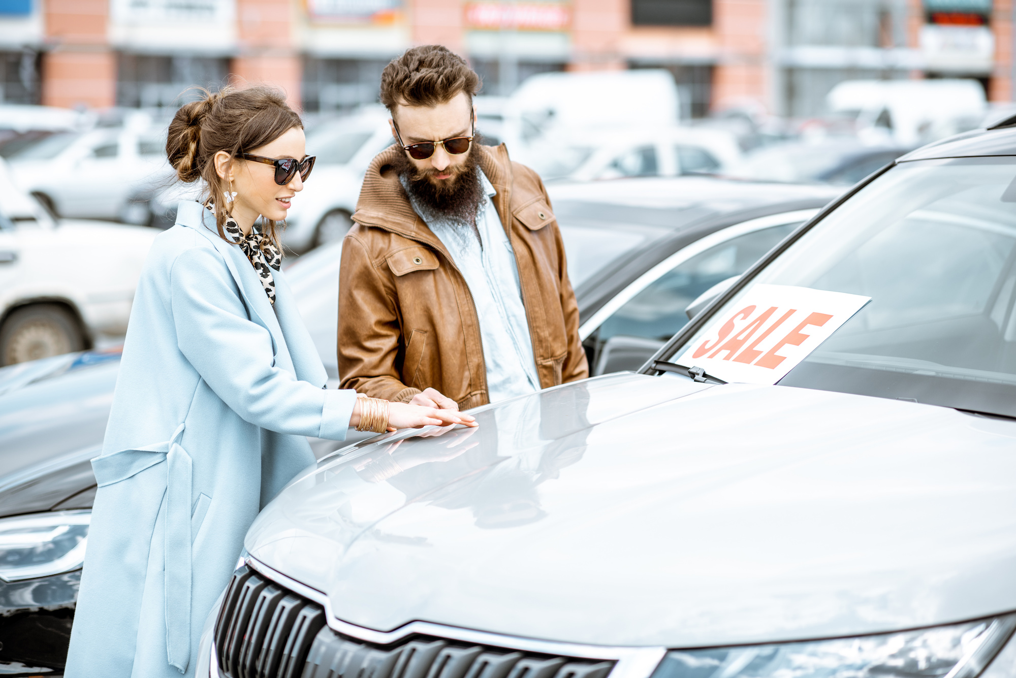 couple choosing luxury car to buy on the open ground of the dealership