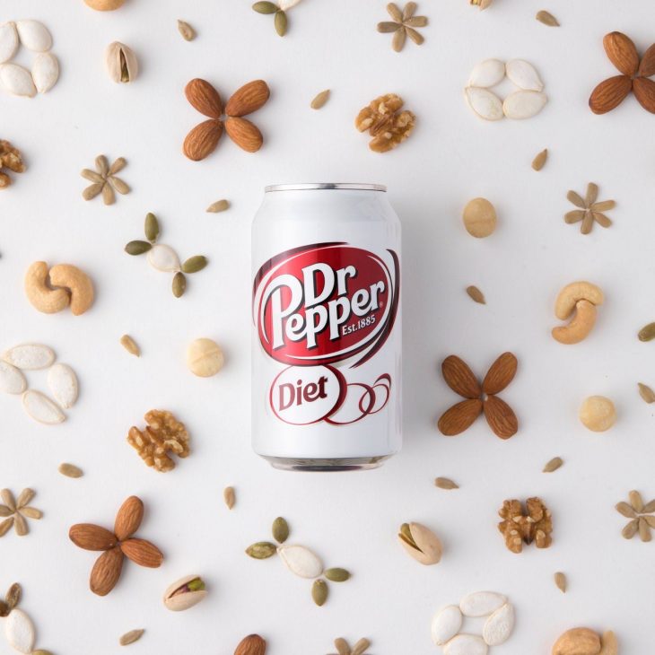 diet dr.pepper on white background decorated with various nuts