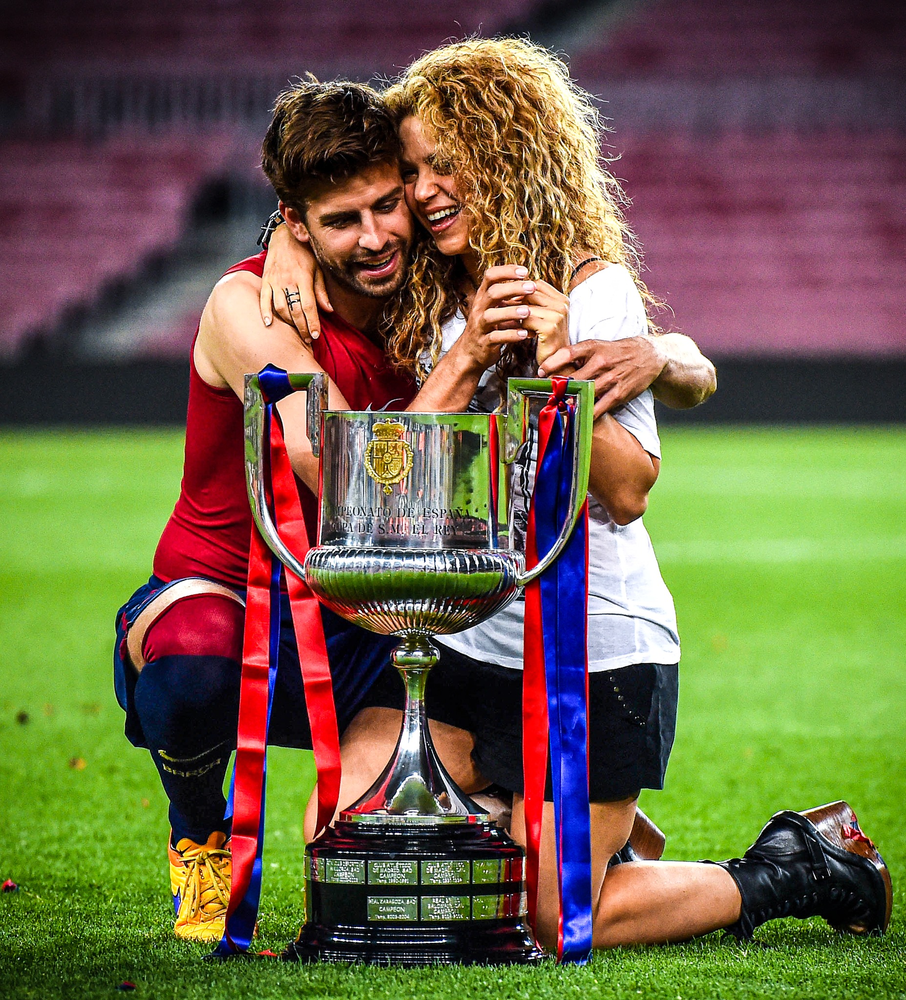 gerard and shakira hugging with world cup trophy