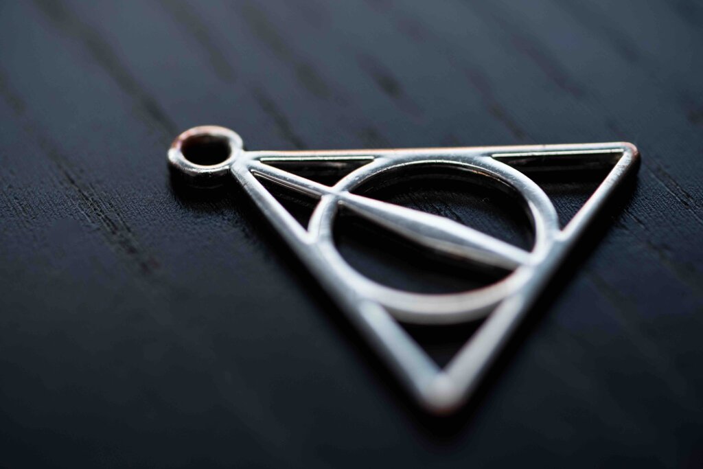 close up silver necklace focus deathly hallows.