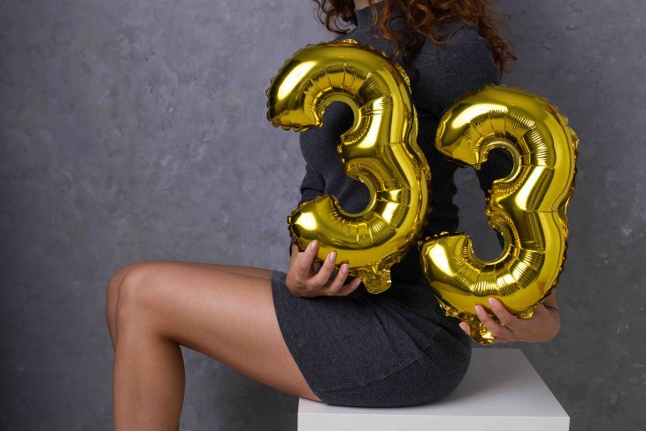 33 years old birthday celebration party, beautiful woman holding gold balloons