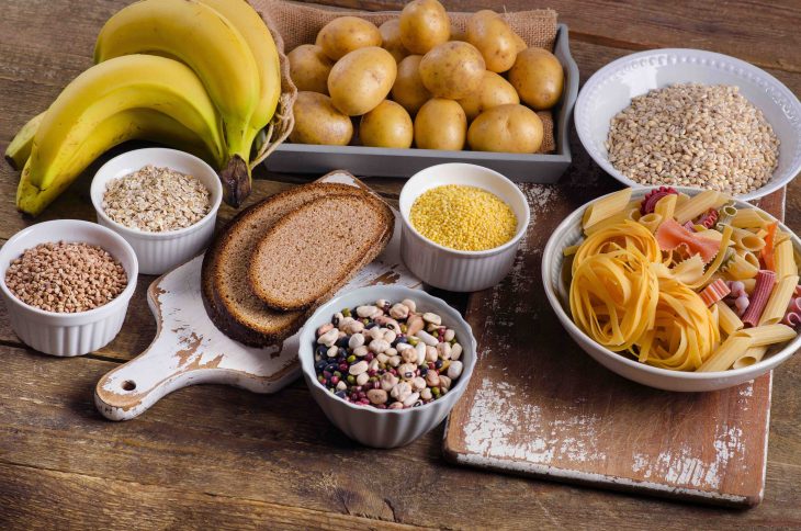 Foods high in carbohydrate on rustic wooden background. Top view