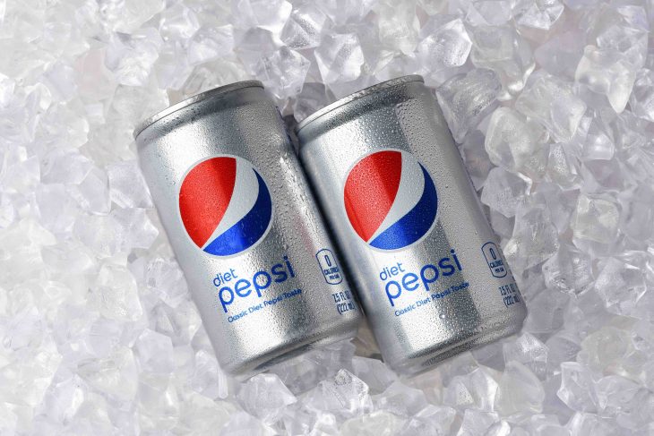 Two cans of Diet Pepsi in a bed of ice.