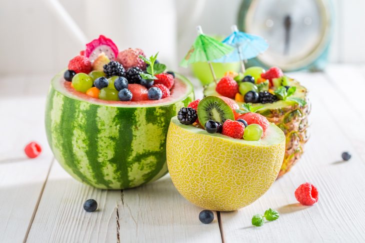 Fruits salad in melon and pineapple with berry fruits