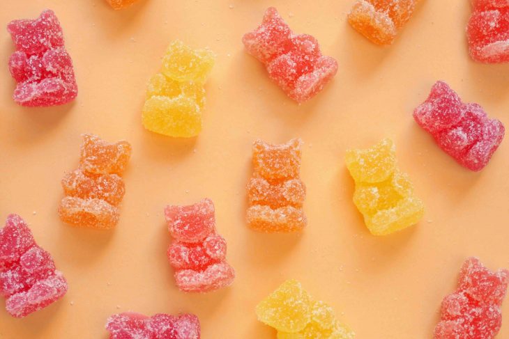 sour gummy bears flat lay on light orange background shot