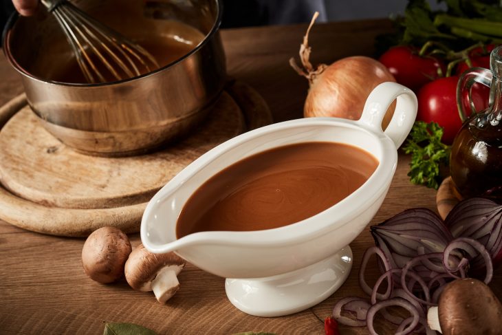 Gravy boat with serving of delicious rich brown sauce