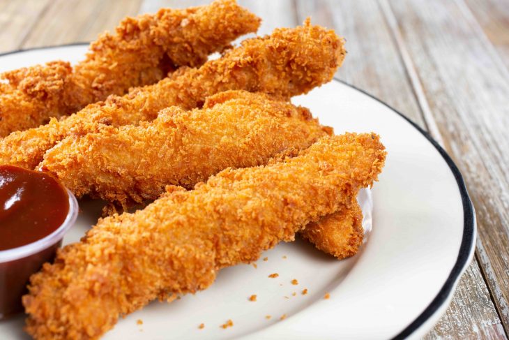 A view of a plate of breaded chicken fingers.