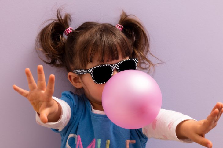 cute little girl blowing bubblegum
