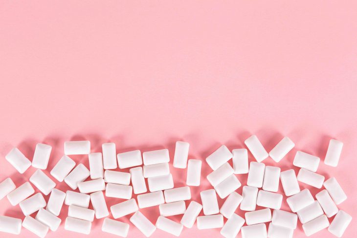 white bubble gum pills on pink background