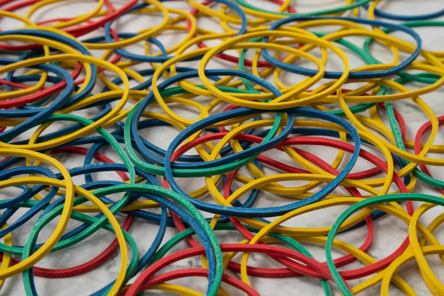 Pile of small round colorful rubber bands for making rainbow loom